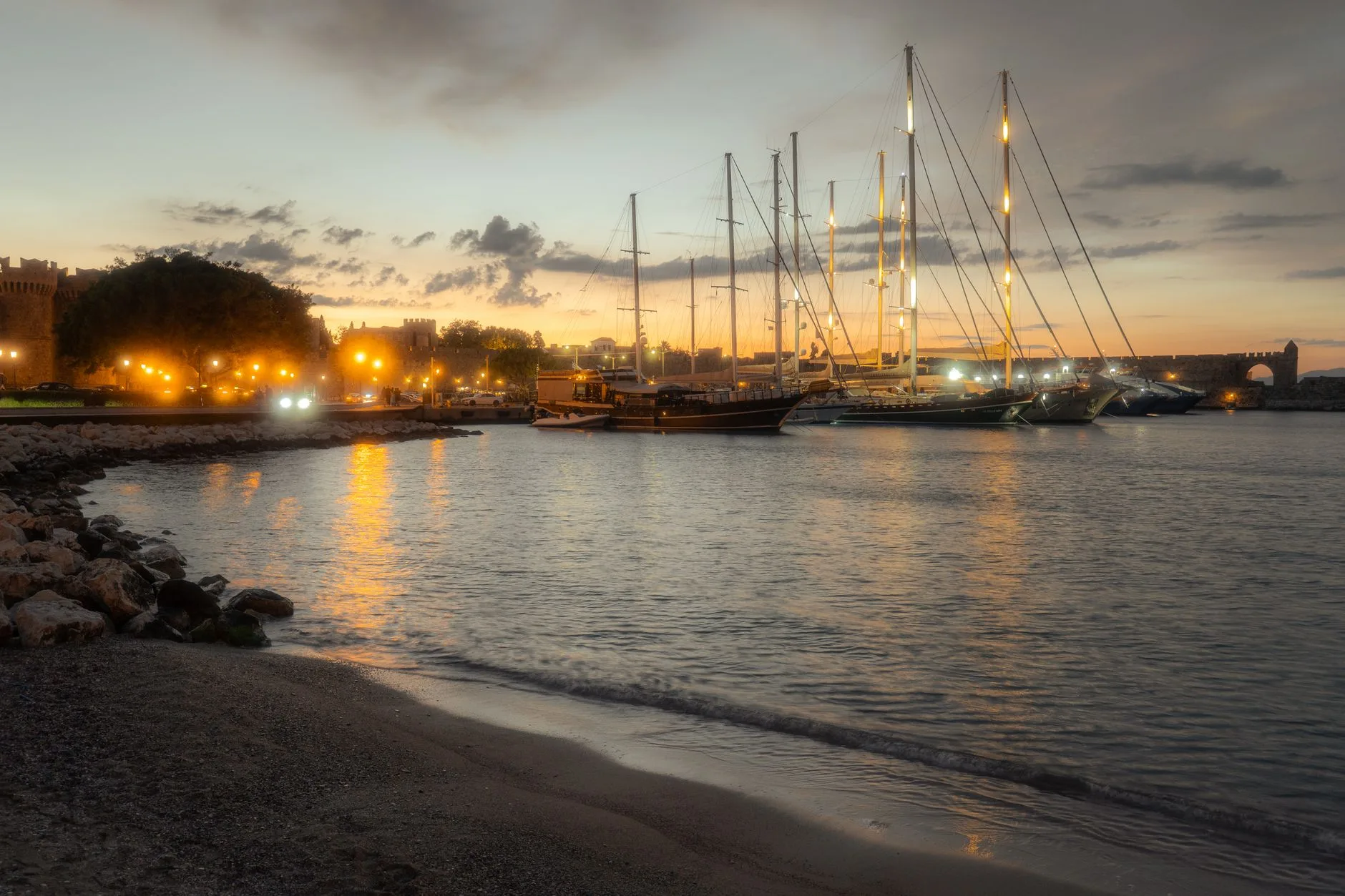 Port de Mandraki à Rhodes au coucher du soleil, avec des bateaux illuminés